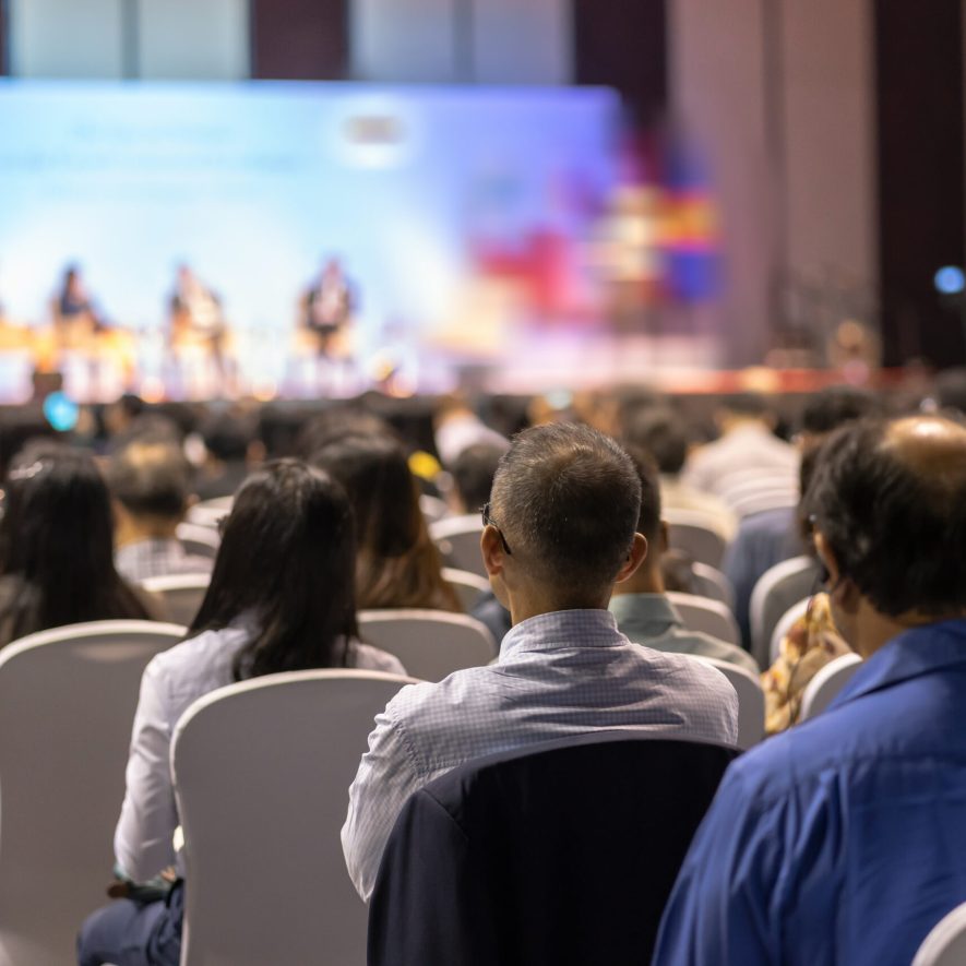 Rear view of Audience listening Speakers on the stage in the conference hall or seminar meeting, business and education about investment concept